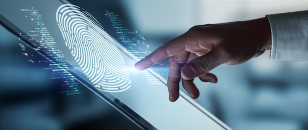 Hand hovers over a laptop screen showing a biometric authentication interface with subtle digital glitches, symbolizing pa...