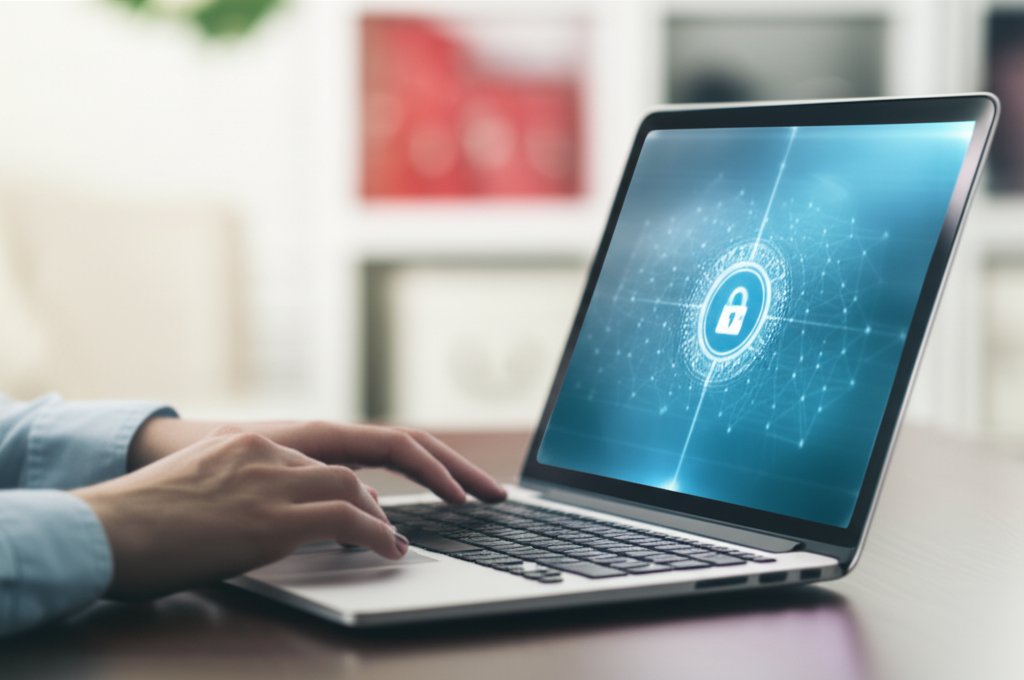 Professional's hands at a laptop displaying a data access control interface in a modern home office for zero trust remote ...